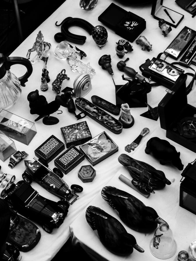 A table of assorted lots laid out for viewing, photographed in black and white